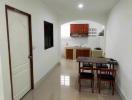 Modern kitchen with dining area, clean design, and tiled flooring