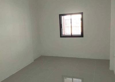 Spacious empty room with tiled flooring and a window