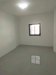 Spacious empty room with tiled flooring and a window