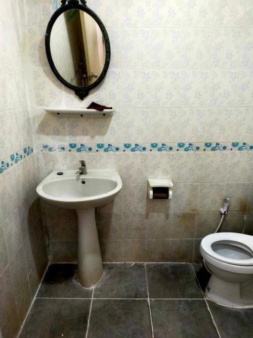 Compact bathroom with pedestal sink, toilet, and mirrored medicine cabinet