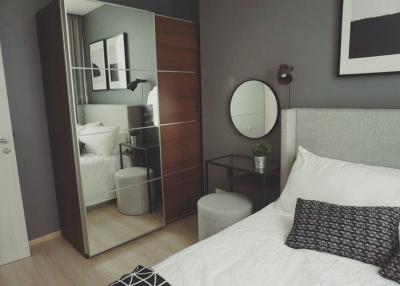 Modern bedroom interior with queen-sized bed and wall-mounted mirrors