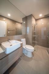 Modern bathroom interior with glass shower, toilet, and sink