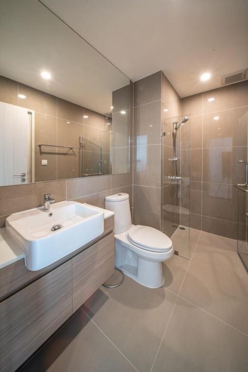 Modern bathroom interior with glass shower, toilet, and sink