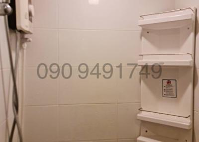 Compact bathroom with wall-mounted shelving and water heater