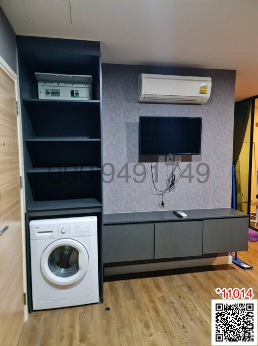 Compact space showing entertainment and laundry units with wooden flooring