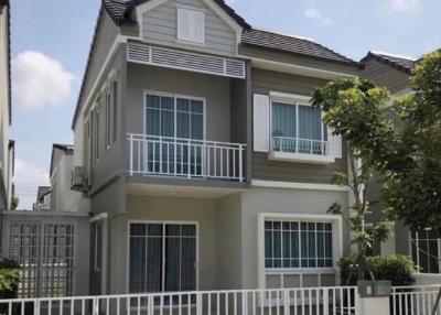 Two-story residential home with balcony and gated fence