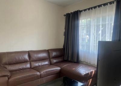 Spacious living room with large windows and leather sofa