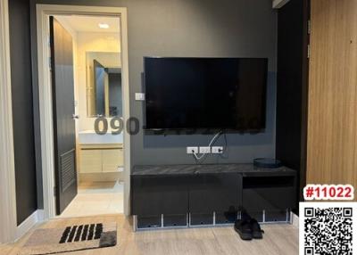 Modern living room interior with mounted television and adjacent bathroom