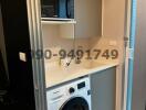 Compact laundry room with modern washing machine and storage shelves