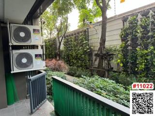 Outdoor utility area with air conditioning units and greenery
