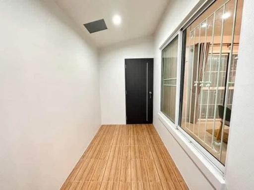 Brightly lit hallway with wooden flooring