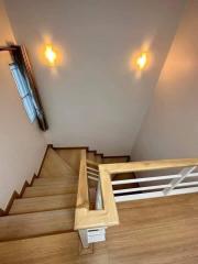 Wooden staircase with light fixtures on the wall