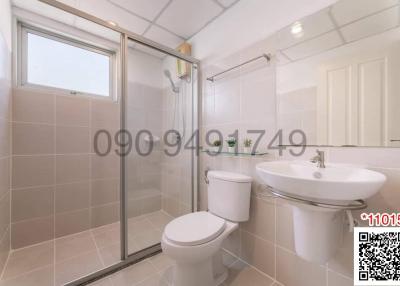 Modern bathroom with a glass shower enclosure, toilet, and sink