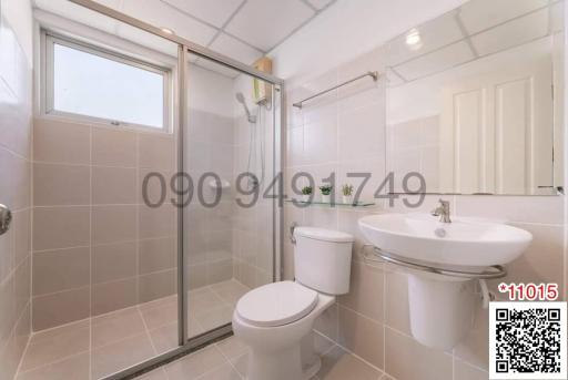 Modern bathroom with a glass shower enclosure, toilet, and sink