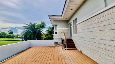 Spacious wooden deck of a modern suburban home with lush greenery