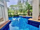 Inviting outdoor pool area with blue tiles and surrounding greenery