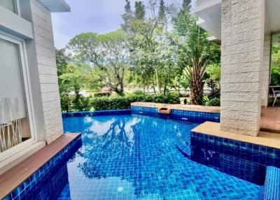 Inviting outdoor pool area with blue tiles and surrounding greenery