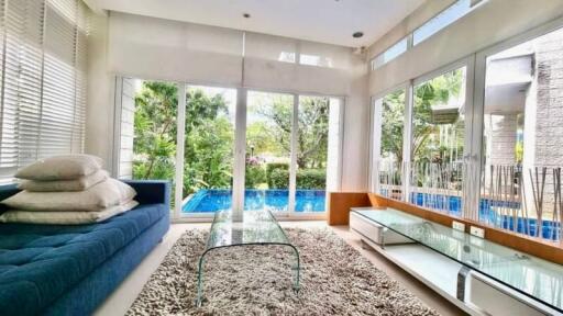 Spacious living room with large windows overlooking a swimming pool