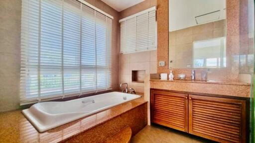 Spacious bathroom with a large bathtub, modern fixtures, and natural light
