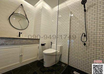 Modern bathroom with white subway tiles, walk-in shower, and wall-mounted toilet