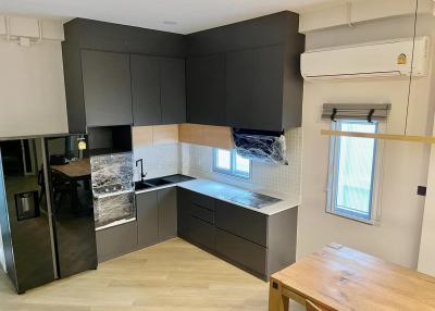 Modern kitchen with black cabinetry and new appliances