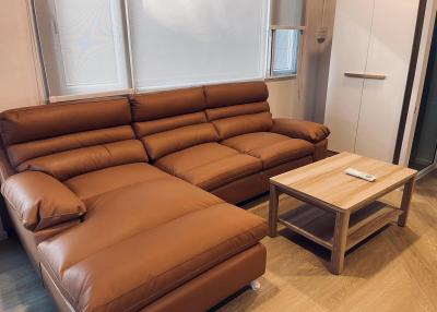 Modern living room with a large brown leather sofa and a wooden coffee table
