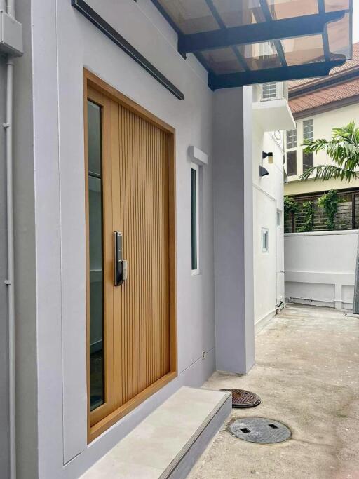 Exterior view of a modern building entrance with a wooden door and a small porch area