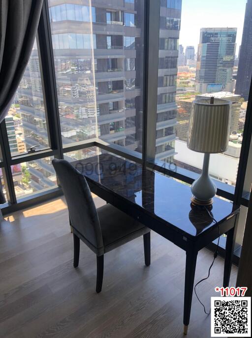 High-rise apartment interior with city view, a table, and a chair