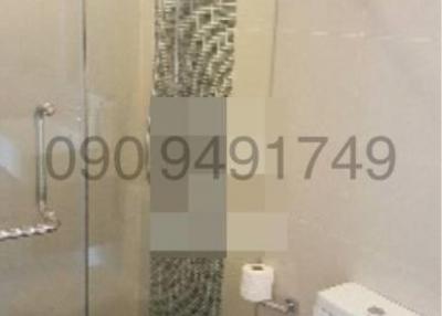 Modern bathroom with glass shower enclosure and mosaic tiles