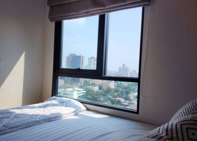 Cozy bedroom with large window offering city views