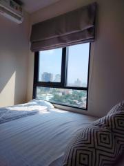 Cozy bedroom with large window offering city views