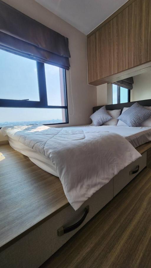 Modern bedroom with large window and wooden furnishings