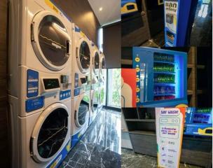 Modern residential laundry room with multiple washing machines and vending machines