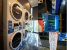 Modern residential laundry room with multiple washing machines and vending machines