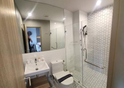 Modern bathroom with glass shower and white hexagonal tiles