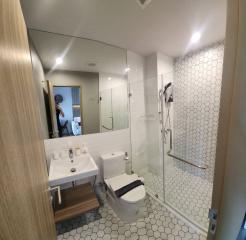 Modern bathroom with glass shower and white hexagonal tiles