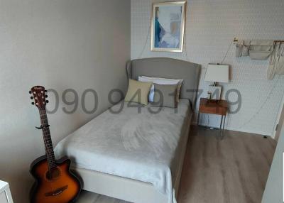 Cozy bedroom with a single bed and guitar