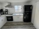 Modern kitchen with stainless steel appliances and tiled flooring