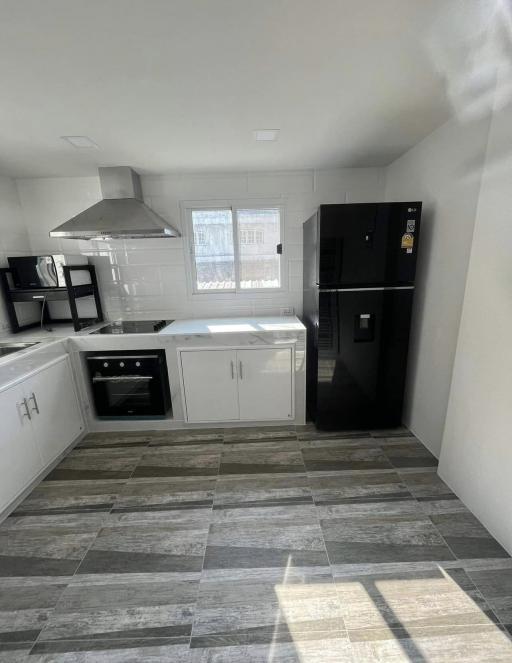 Modern kitchen with stainless steel appliances and tiled flooring