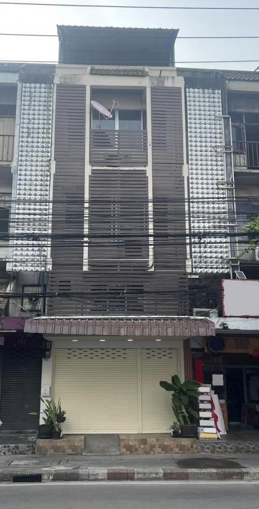 Three-story residential building facade with shutter windows