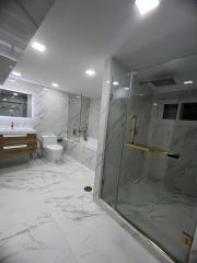 Modern bathroom with marble tiles and glass shower enclosure