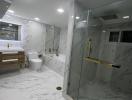 Modern bathroom with marble tiles and glass shower enclosure