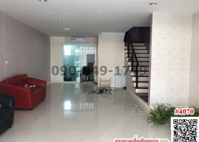 Spacious living room with staircase and tile flooring