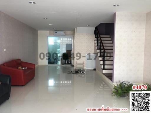 Spacious living room with staircase and tile flooring