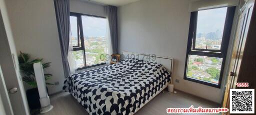 Cozy bedroom with a large bed and cityscape view through large windows