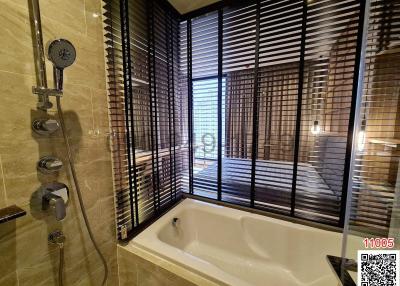 Modern bathroom with city view, featuring bathtub and shower