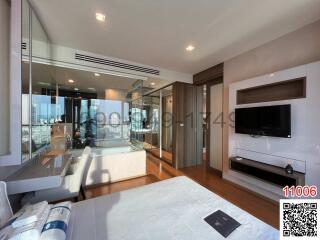 Modern bedroom with a view, featuring a comfortable seating area and entertainment system