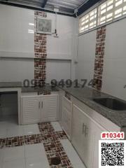 Modern kitchen with white cabinetry and tiled flooring