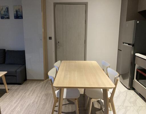 Modern dining space with wooden table and adjacent living area