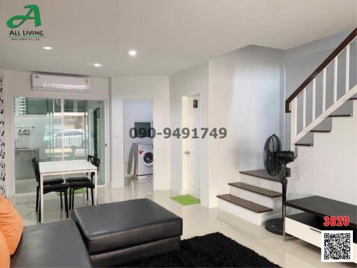 Modern living room with open layout, dining area, and staircase